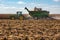 A John Deere combine is filling a grain hopper