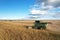 John Deere combine harvester working on harvesting rapeseed. Farm Harvest season in rural. Harvester for agriculture work.