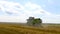 The John Deere combine harvests ripe wheat