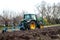 John Deere green tractor plowing in autumn, farmer plowing stubble on tractor, preparation