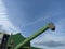 John Deere harvester works in the field. Combine Harvesting Wheat