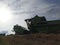 John Deere harvester works in the field. Combine Harvesting Wheat