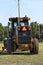 John Deere road grader in a field with green grass and blue sky in Kansas.