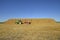 John Deere tractor by huge square bale stack