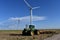 John Deere Tractor with Texas Windmills against Blue Sky with White Clouds