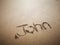 A John name written on the beach.