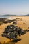 John Obey Beach with black rocks, smooth yellow sand beach, sea and mountains in background, Sierra Leone, Africa