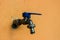JOHOR, MALAYSIA - AUGUST 2, 2020: Water Faucet with Orange Wall Background
