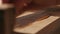 A joiner applies a wood impregnation to a wood product. a man covers a wooden shelf with oil for wood