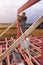 Joiner on roof installation, hammer hammering nail into wooden beam