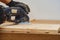 Joiner tools. Sanding wooden board with a hand-held electric sander