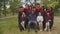 Joint portrait of academic staff and multiracial graduates outdoors