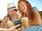 Jokes are made for sharing. Two adolescent girls enjoying smoothies while texting on a cellphone.