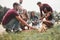 Joking around. Group of people have picnic on the beach. Friends have fun at weekend time