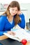 Jolly female teenager studying in the kitchen