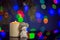 Jolly snowman toy and burning candle on sparkling and fabulous bokeh background with copy space. Christmas background for