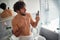 Jolly topless man texting while brushing teeth