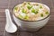 Jook slightly salted rice porridge with chicken, peanuts and green onions close-up in a bowl. horizontal