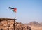 Jordanian flag waving in the wind at a viewpoint in the ancient city of Petra, Jordan