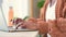 Journalist student typing a report on a laptop from her home. Closeup of the hands of a female freshman studying and