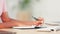 Journalist taking notes and planning their next story while studying at a desk in an office alone at work. Student doing