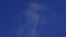 The journey begins, plane flies high in the sky, leaving a white trail. Jet airplane flying overhead in clear blue sky
