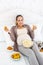 Jovial pregnant woman swallowing junk food