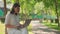 Joyful adorable beautiful business Senior woman wearing eyeglasses sittingin park outdoors, working on a laptop. Modern