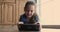 Joyful adorable little kid girl using digital tablet alone indoors.