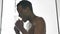 Joyful African-American man sings taking hot shower at home