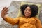 A joyful African American woman with a vivacious smile lies on a pillow