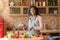 Joyful african lady mixing veggies in bowl in kitchen