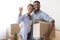 Joyful Afro Spouses Showing Key Embracing Holding Box After Relocation