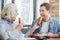 Joyful aged woman and grandson eating patties in the cafe