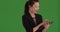 Joyful asian business lady using tablet device for work standing on greenscreen