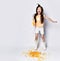 Joyful asian girl kid in home clothes laughs, jumps and does not notice she is spilling out corn flakes on gray