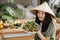 Joyful asian woman in traditional conical hat holding healthy salad from organic vegetables