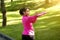 Joyful athletic black lady stretching arms, training at park