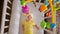 Joyful baby girl in yellow lies in white crib with mobile