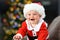 Joyful baby wears santa costume in christmas