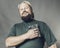 Joyful bearded craftsman in green t-shirt having fun with staple gun