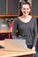 Joyful beautiful young woman with laptop in kitchen for telecommuting