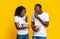 Joyful black couple eating popcorn on yellow