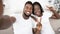 Joyful black couple taking selfie and showing peace gesture at home