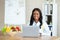 Joyful black female dietitian with laptop consulting patient online at clinic, empty space