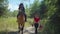 Joyful black female riding on horseback in forest