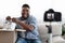 Joyful Black Man Blogger Recording Unboxing Video Of New Pair Of Shoes