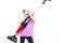 Joyful blond girl holding a vacuum cleaner and fooling to  playing guitar on white background