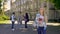 Joyful blonde girl standing away from her classmates, waiting for boyfriend