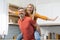 Joyful blonde lady piggybacking her cheerful husband, kitchen interior